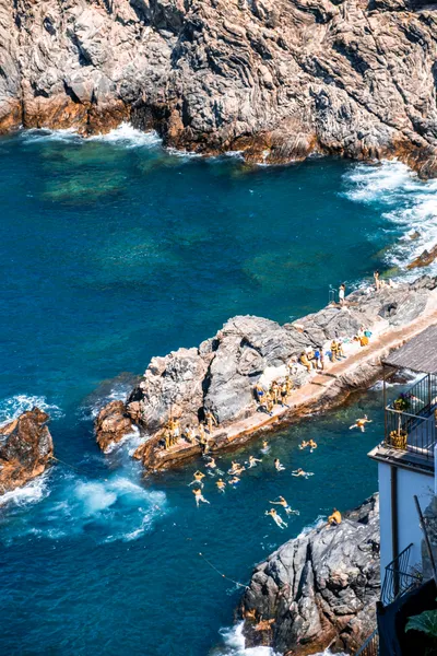 Rocky coastline with swimmers in turquoise sea