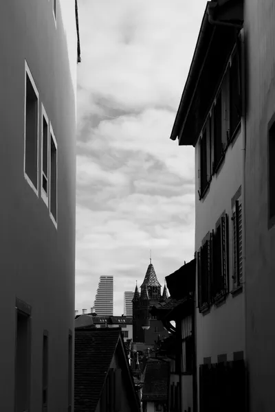 View between buildings towards Basel skyline in black and white