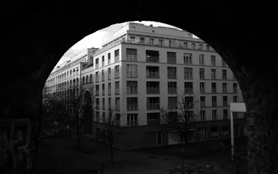 View through a tunnel towards an apartment building in black and white